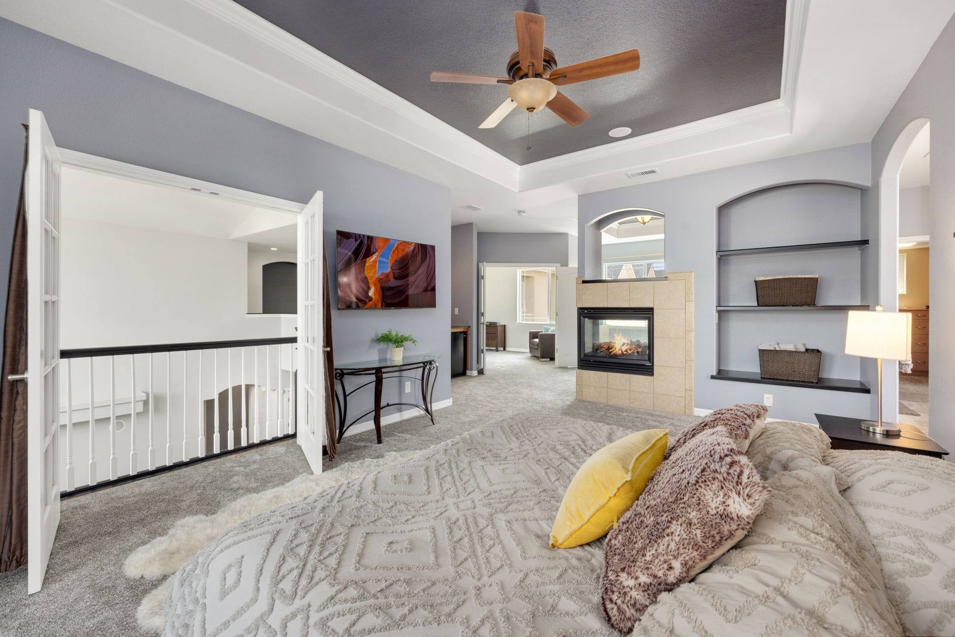 Spacious bedroom featuring a fireplace, stylish decor, and modern furnishings.
